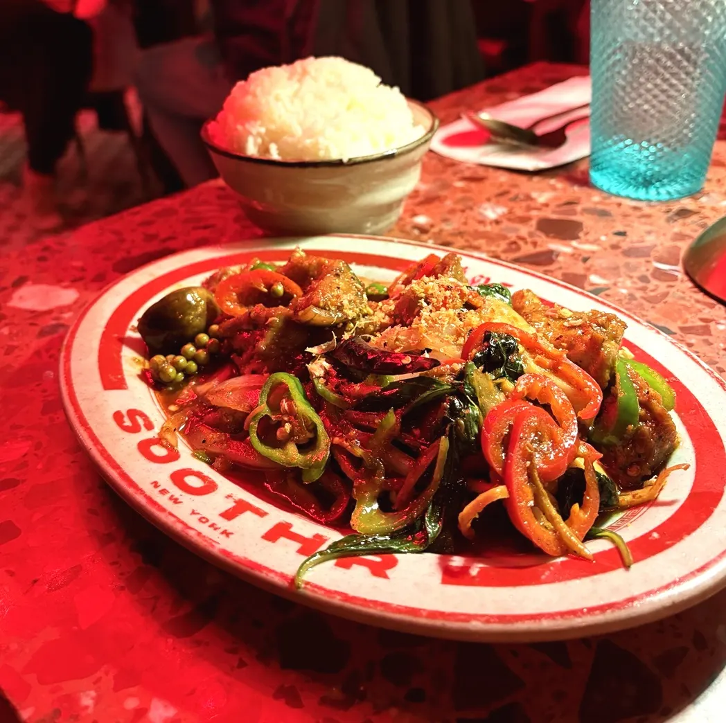 Vegan Duck Jungle on a red-rimmed Soothr plate, with a bowl of rice