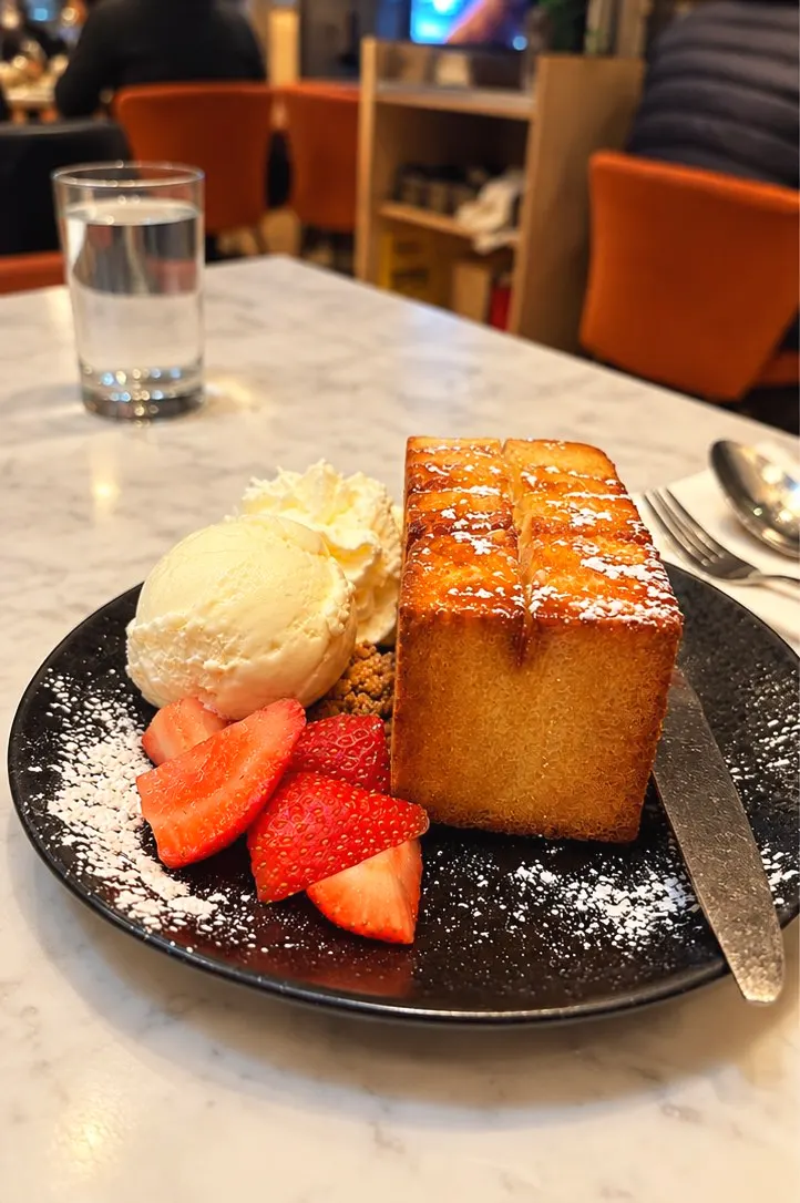 Golden Toast: a thick block of buttered toast with powdered sugar, vanilla ice cream, whipped cream, cookie crumbs and strawberries